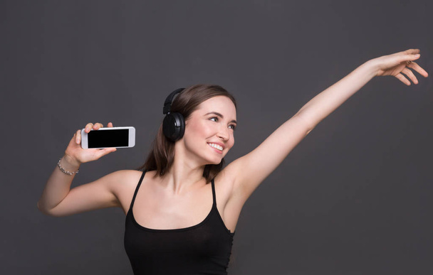 Woman listen to music in earphones, studio shot - Photo, Image