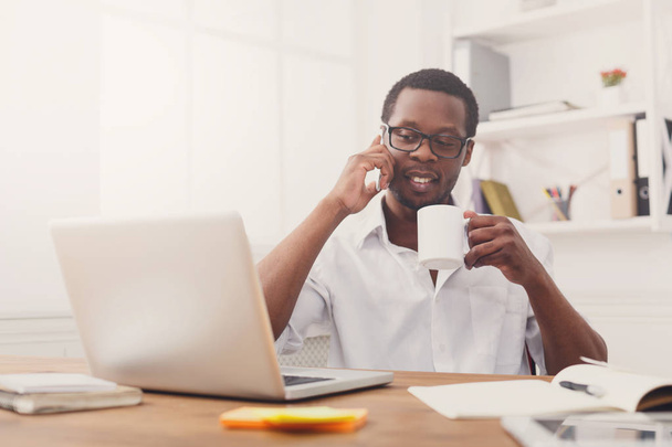 Nuori musta liikemies soittaa matkapuhelin moderni valkoinen toimisto
 - Valokuva, kuva