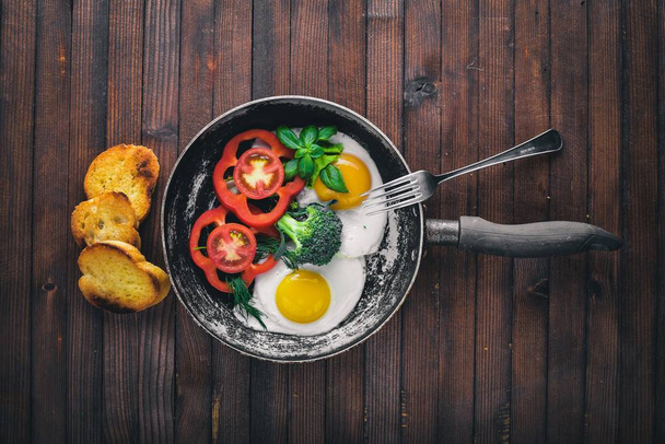Fried egg with herbs, toast bread and vegetables in a frying pan. Top view. Free space. - Fotografie, Obrázek