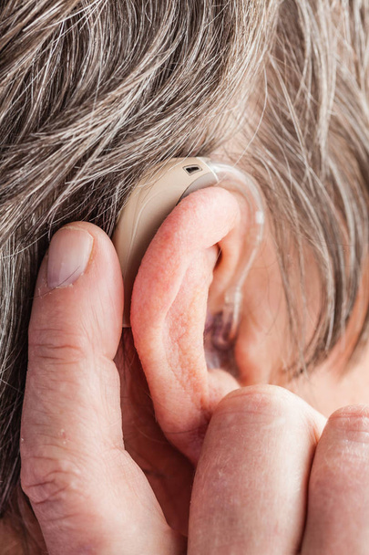 Closeup senior woman using hearing aid - Foto, immagini