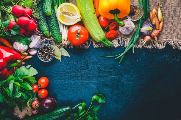 Keret bioélelmiszerek. Friss nyers zöldségek és fűszerek. A fából készült chalkboard. - Fotó, kép