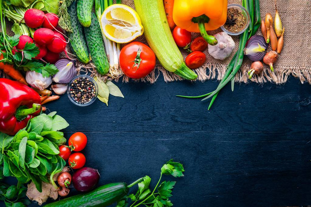 有機食品のフレームです。新鮮な生の野菜やスパイス。木製黒板. - 写真・画像