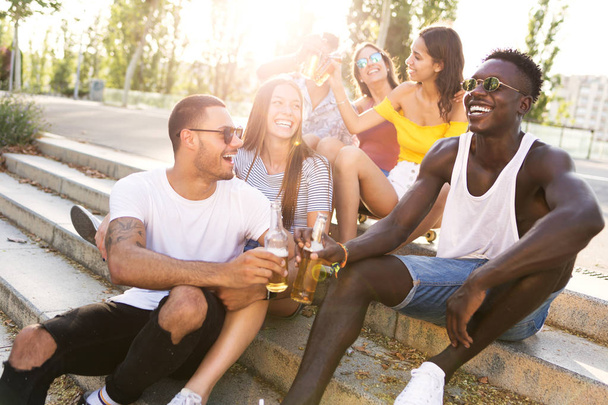 Group of young people toasting with beer in an urban area. - Foto, Imagen