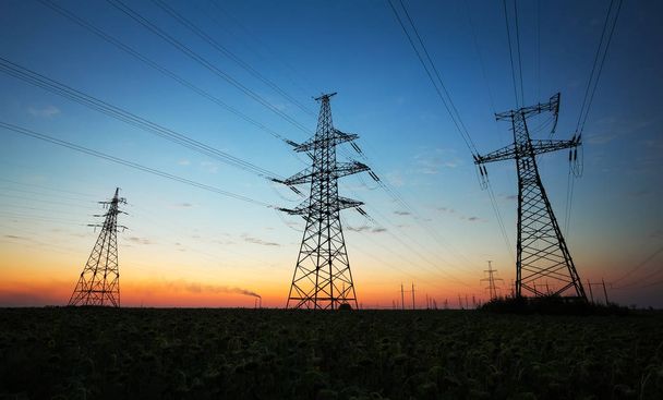 Silhouette de pylônes électriques et lignes électriques haute tension sur
 - Photo, image