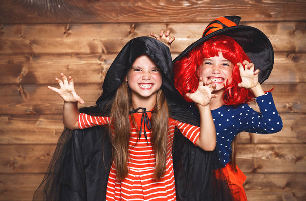grappige kinderen zus tweeling meisje in heks kostuum in hallowee - Foto, afbeelding