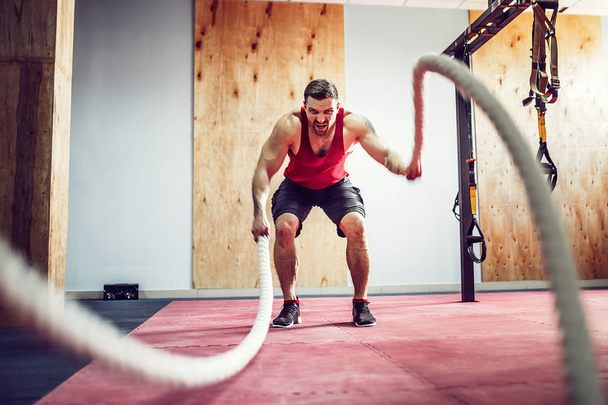 Mężczyzn z bitwy liny w fitness trening funkcjonalny - Zdjęcie, obraz