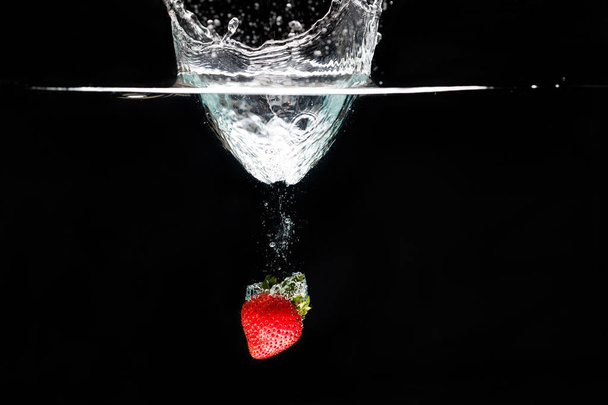 A strawberry splashing into water - Photo, image