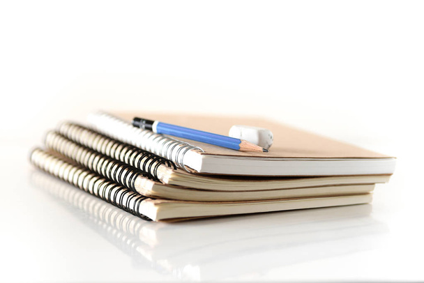 Stapel notitieboekje met potlood en gum - Foto, afbeelding