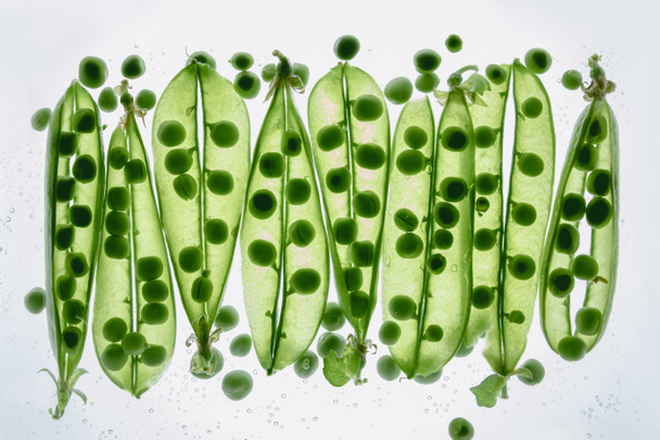 水に浮かぶ緑エンドウ豆 - 写真・画像