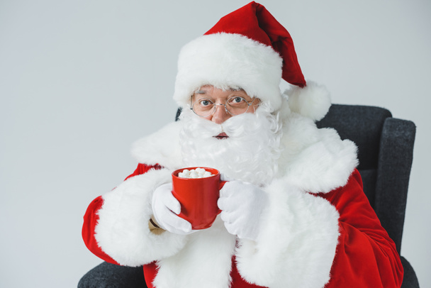 Santa drinken warme chocolademelk met marshmallows - Foto, afbeelding