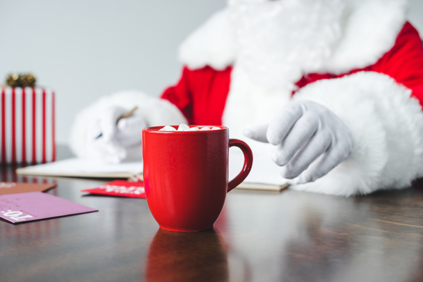 Weihnachtsmann trinkt heiße Schokolade mit Marshmallows - Foto, Bild