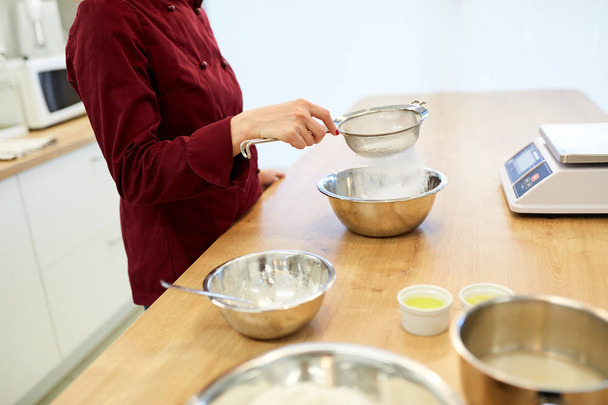 chef sifting flour in bowl making batter or dough - Fotoğraf, Görsel