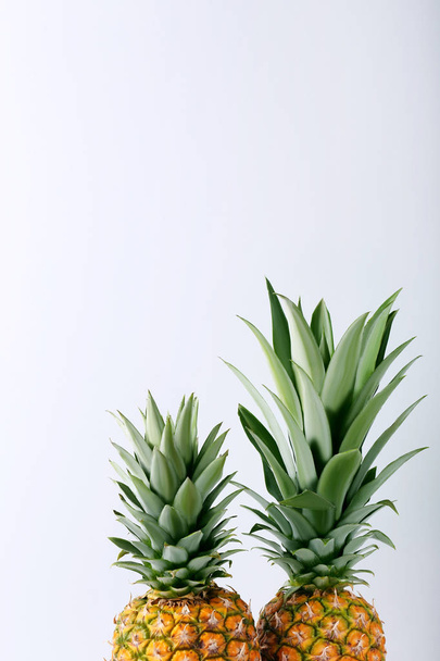 Ripe pineapples on grey background - Fotoğraf, Görsel