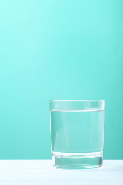 Glass with water on mint background  - Foto, immagini