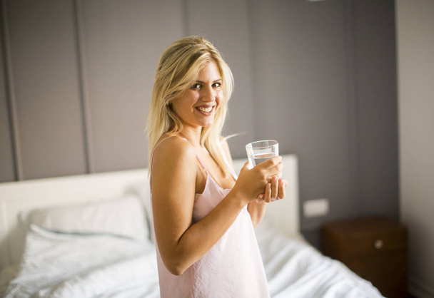 hübsche junge Frau trinkt Wasser aus Glas - Foto, Bild