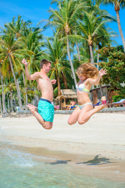 Νεαρό ζευγάρι - νεόνυμφοι - διασκεδάζουν στην τροπική παραλία του Κ - Φωτογραφία, εικόνα