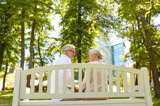 Glückliches Seniorenpaar sitzt auf Bank im Park - Foto, Bild