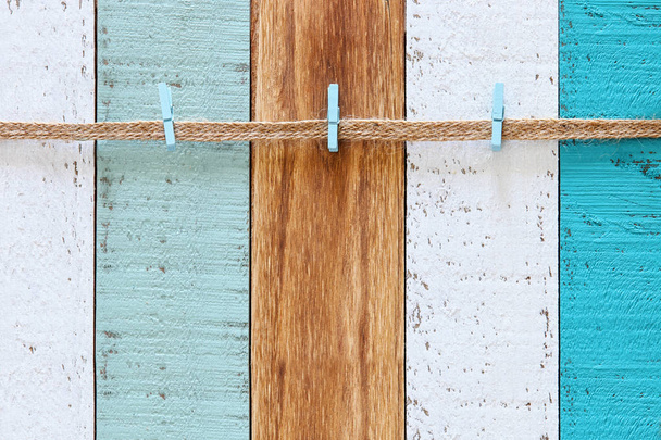 A rope with clips over background of vintage wooden planks in blue, aqua, turquoise and white - Photo, Image