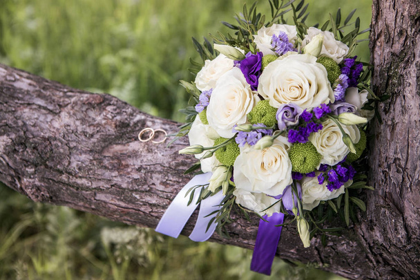 White roses with blue and lavender flowers bouquet. Wedding ring macro photography. - Photo, Image