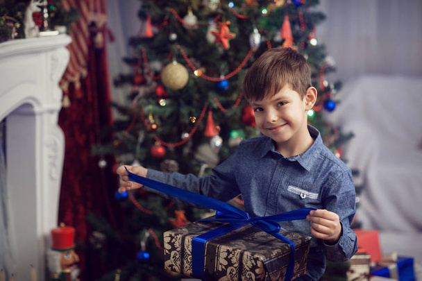 The boy at the New Years Eve opens a gift - Fotó, kép