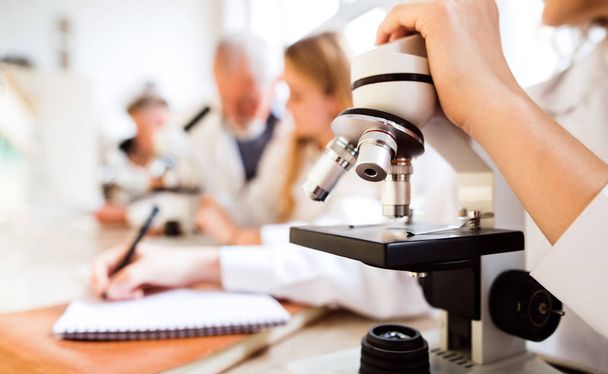 Unrecognizable high school student with microscope in laboratory - Foto, immagini