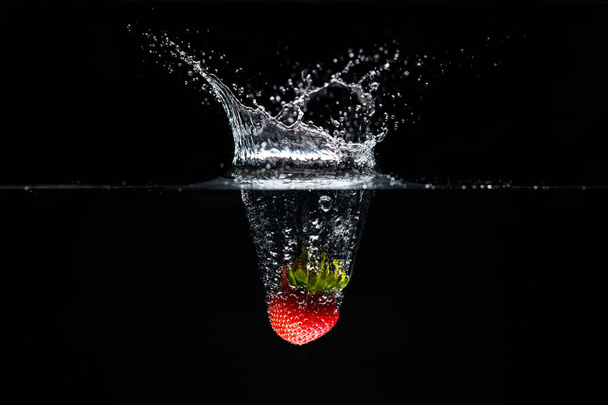 A strawberry splashing into water - Foto, immagini