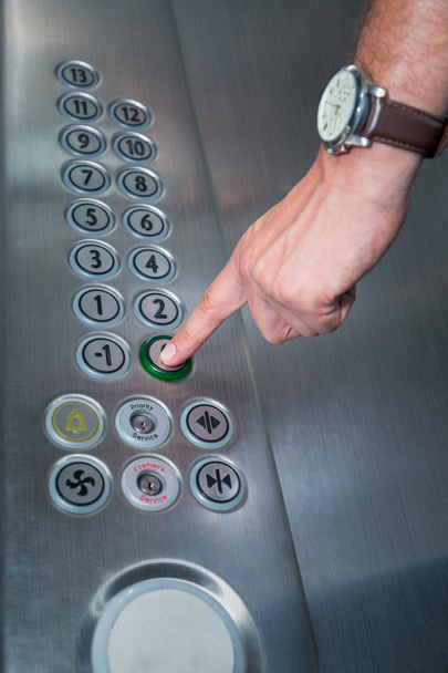 Man pressing the zero floor button in the elevator - Φωτογραφία, εικόνα