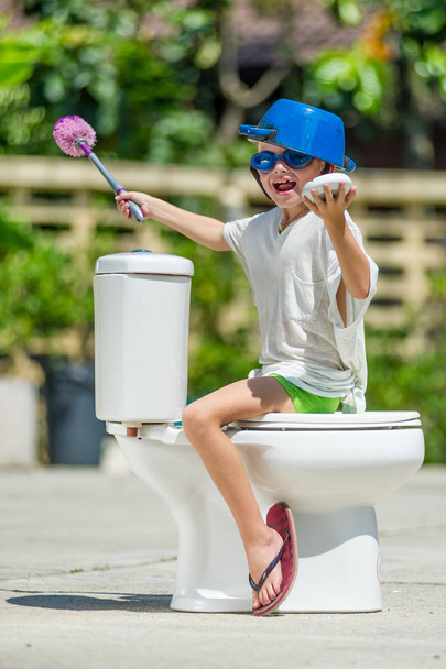 Absurd picture - astride a toilet: cute boy in goggles sitting o - Photo, Image
