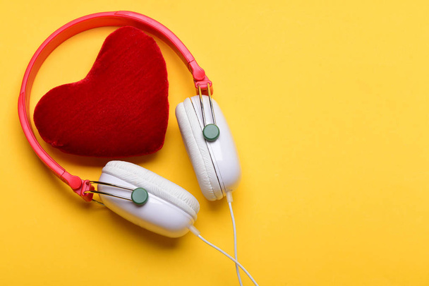 Modern and stylish earphones isolated on warm yellow background - Foto, imagen