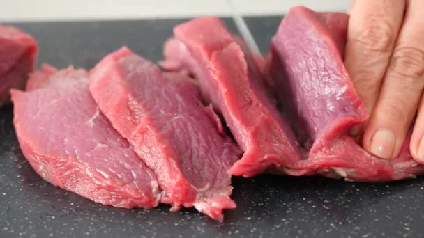 cutting raw beef on a cutting board closeup - Metraje, vídeo