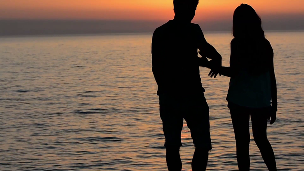 Ojciec i córka oglądać zachód słońca na plaży - Materiał filmowy, wideo