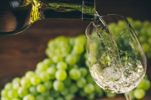 Pouring white wine into a glass  - Foto, Bild