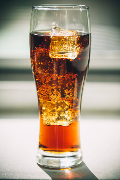 Cola with ice cubes in a glass o - 写真・画像