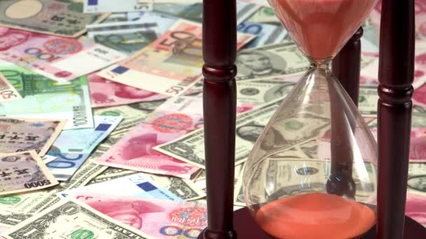 orange sand flowing in hourglass on currency background  - Footage, Video