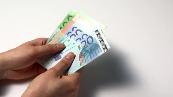 αρσενικό χέρια καταμέτρησης νόμισμα του ευρώ επάνω ελαφρύς υπόβαθρο  - Πλάνα, βίντεο