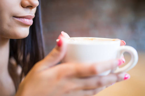 Молодая женщина с чашкой кофе в руках, прежде чем пить
 - Фото, изображение