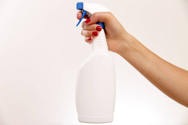 Studio στιγμιότυπο από ένα χέρι που κρατά μια καθαρισμού σπρέι μπουκάλι με το λευκό β - Φωτογραφία, εικόνα