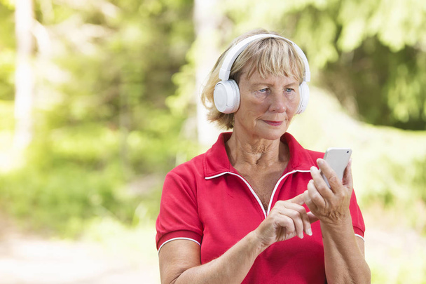 Active senior woman using sport tracking app - Zdjęcie, obraz