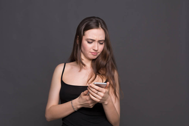 Jeune femme malheureuse utilisant le portrait smartphone
 - Photo, image