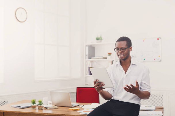 Boldog fekete üzletember modern irodában dolgozik-val tabletta - Fotó, kép
