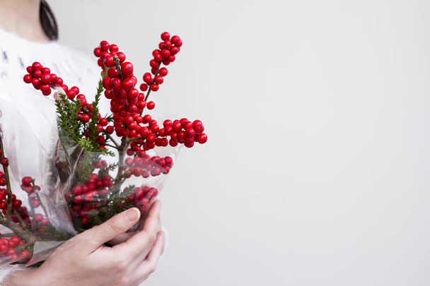 Manos de mujer sosteniendo ilex verticillata o winterberry para la decoración de Navidad
 - Foto, Imagen