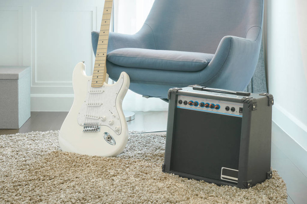 Guitar, amplifier with gray armchair in modern style living room - Valokuva, kuva