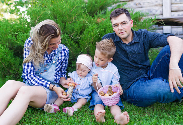 Молодая семья с корзиной грибов в летнем парке
.  - Фото, изображение