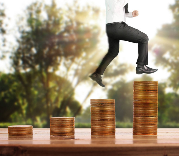 Бізнесмен ходить по стопах монет, які ростуть успішно
  - Фото, зображення