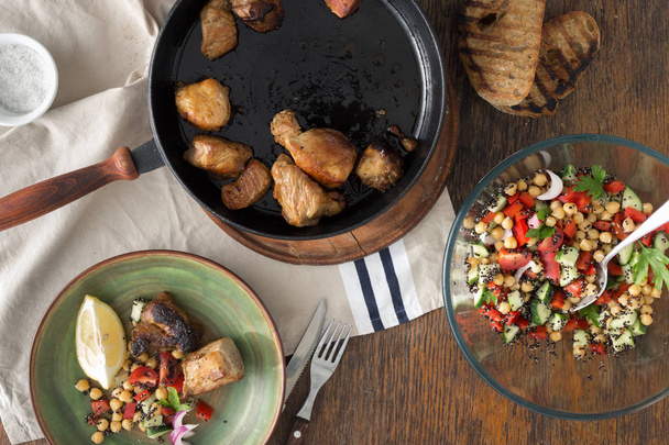 Fried meat in pan on wooden table - Foto, Bild