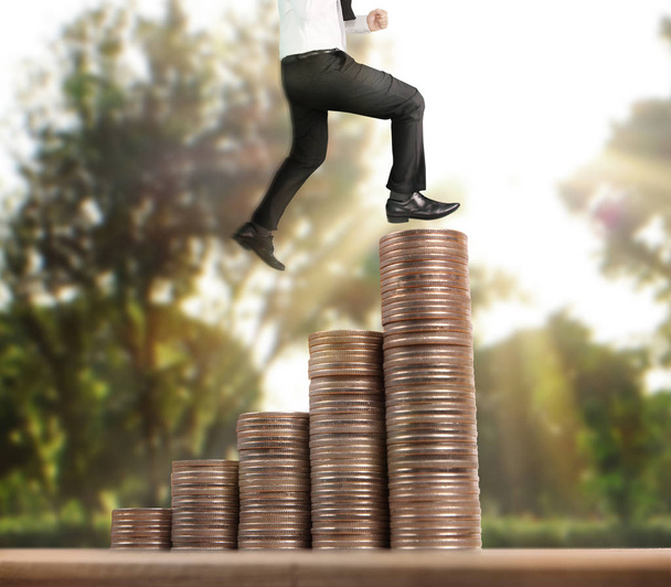 Empresario caminar en pila de monedas que crece el éxito
  - Foto, imagen