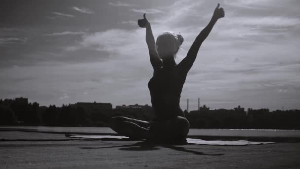 Genç kadının üzerinde nehir kıyısında yoga egzersizleri yapması - Video, Çekim