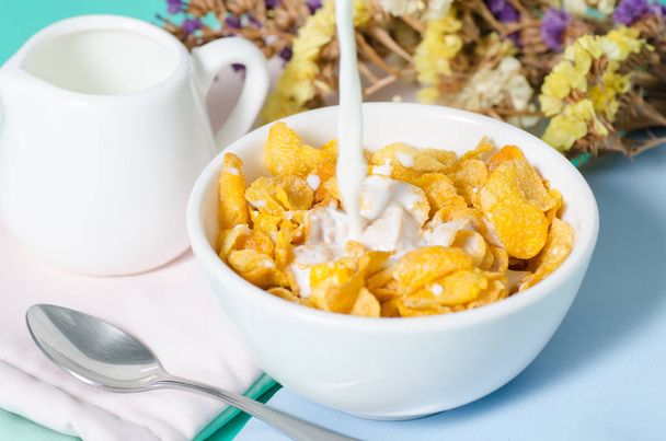 Cornflakes in einer Schüssel mit frischer Milch zum Essen - Foto, Bild