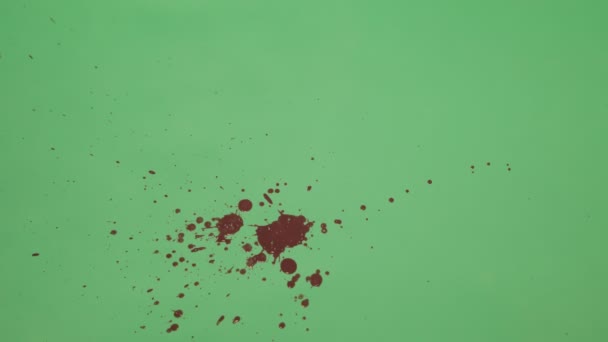 Червоним чорнилом бризки над фоном зелений екран - Кадри, відео