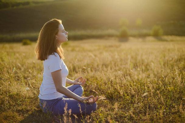 mujer practica yoga y medita en la posición de loto sobre el
  - Foto, Imagen